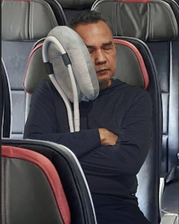 A traveler napping in an airplane seat, head resting on the Prod-UP-tivity napping station